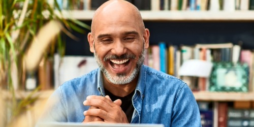 Man engaging with colleagues on his laptop
