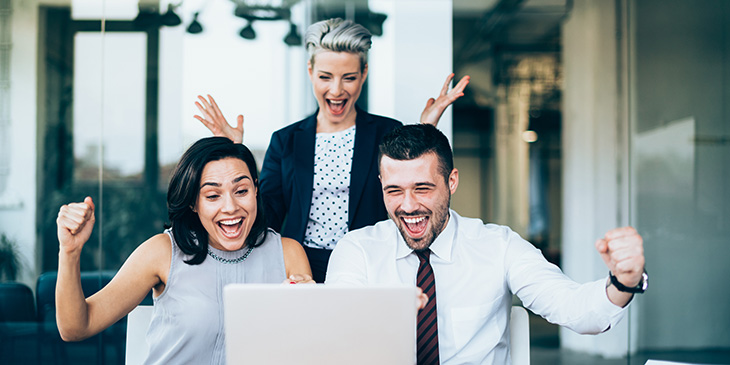 Group of people celebrating at laptop