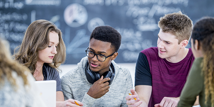 Four school students sat at a desk