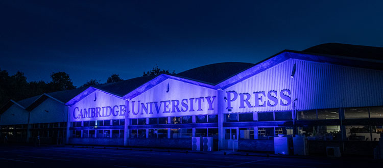 Front of University Printing House lit up in blue lights