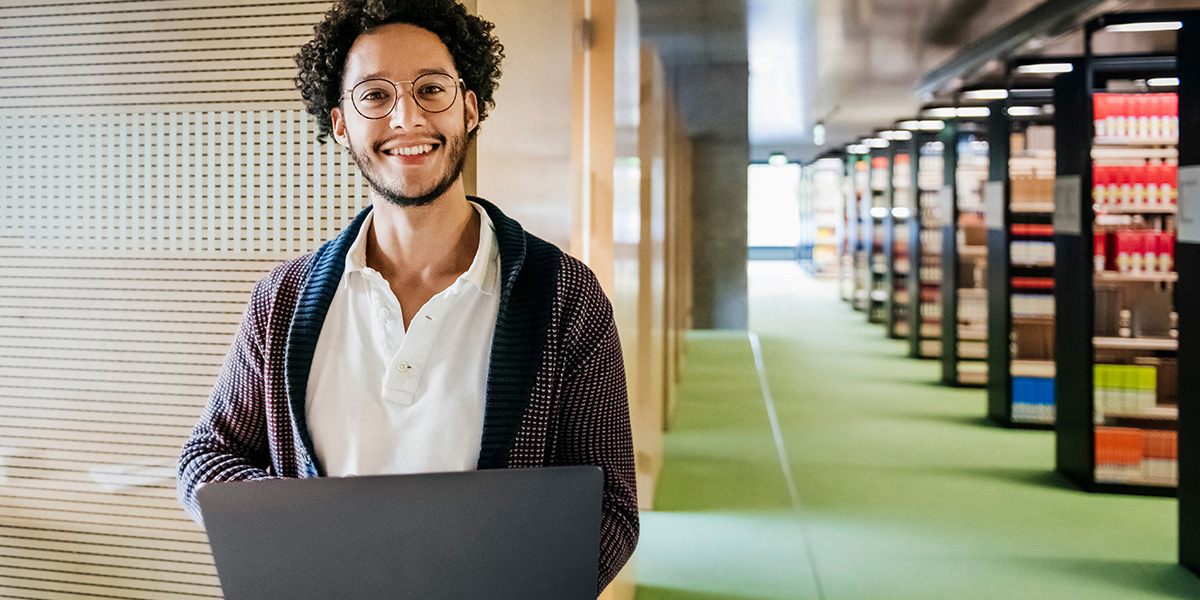 Man with laptop in a library