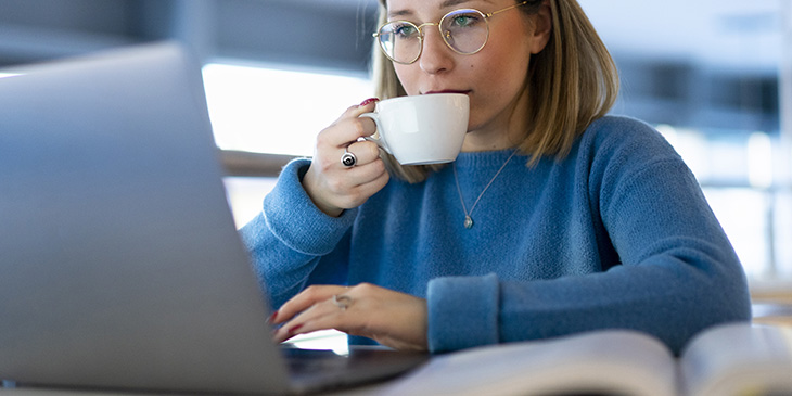 woman at laptop drinking coffee
