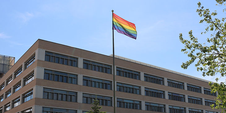 the LGBT+ Pride flag flying outside the Cambridge Assessment Triangle building in Cambridge