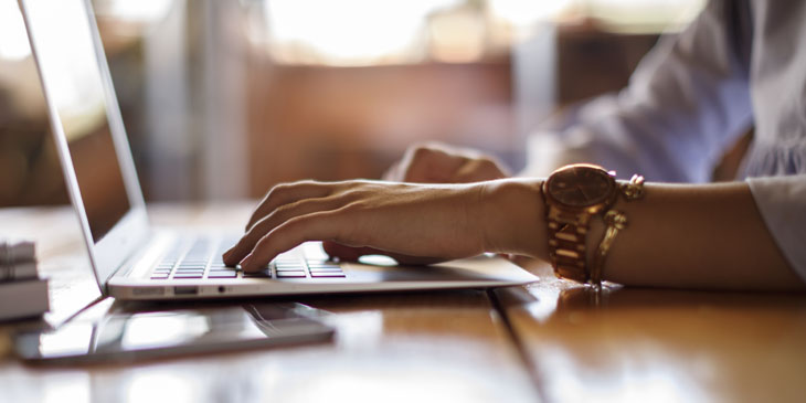 Close-up of the hands of a person working at a laptop