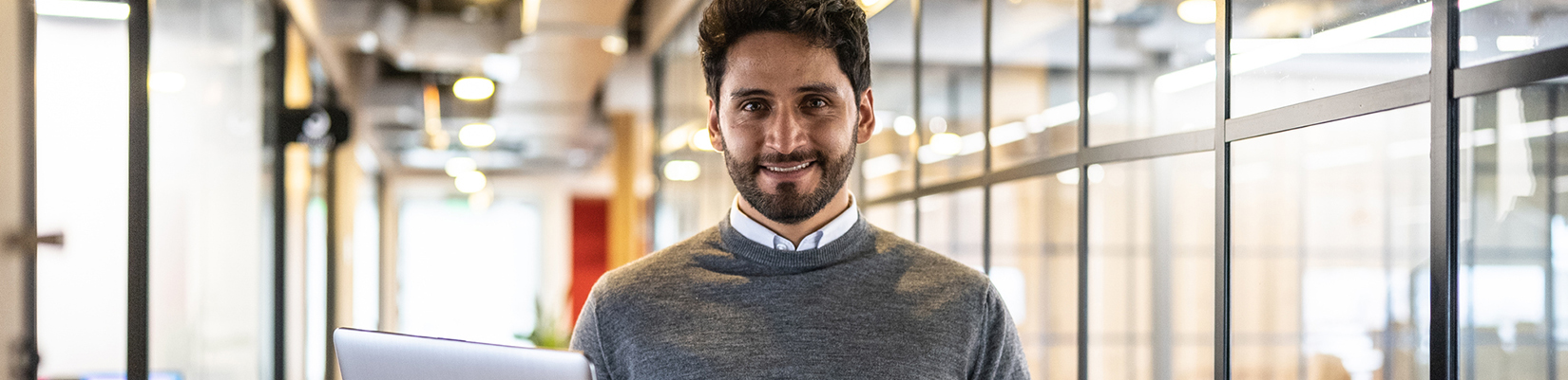 Man smiling holding a laptop