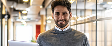 Man smiling holding a laptop