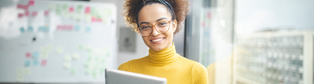 Woman smiling holding a laptop