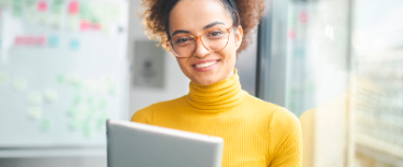 Woman smiling holding a laptop