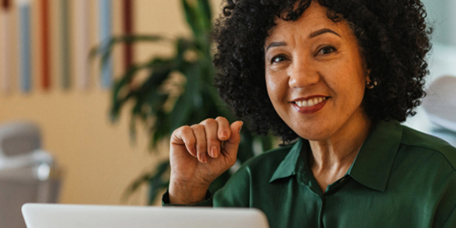Woman with laptop smiling at camera