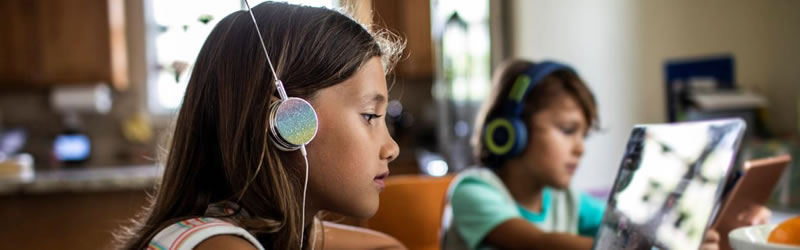 Girl with headphones watching on laptop