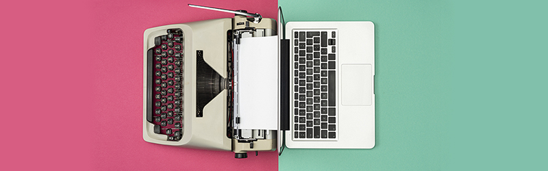 Aerial view of an analogue typewriter opposite a modern laptop computer