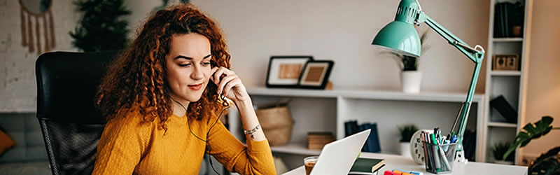 Woman at laptop with books