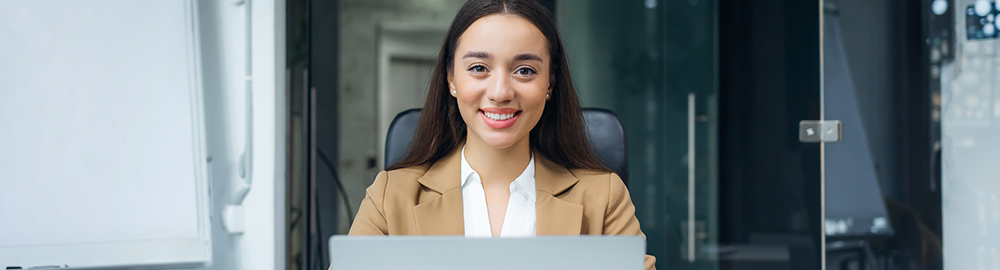 Woman with laptop smiling at camera