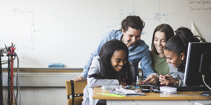 Teacher with group of students looking at an electric circuit