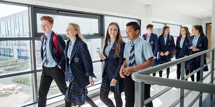 school students walking through corridor 