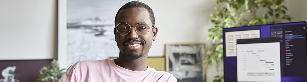 Man at desk smiling at camera