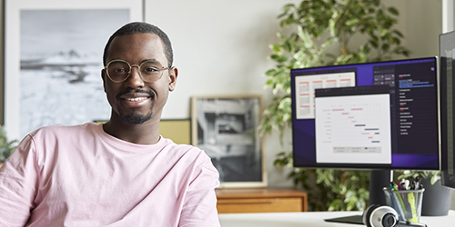 Man at desk smiling at camera
