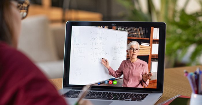 A girl studying through remote learning and watching an online lesson