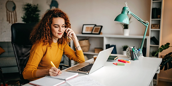 Woman at laptop with books