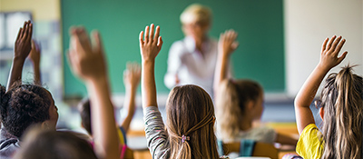 Pupils putting their hand up in class