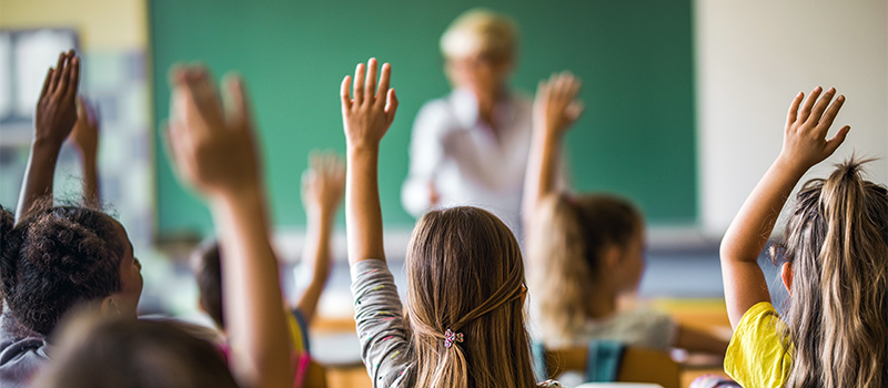 Pupils putting their hand up in class