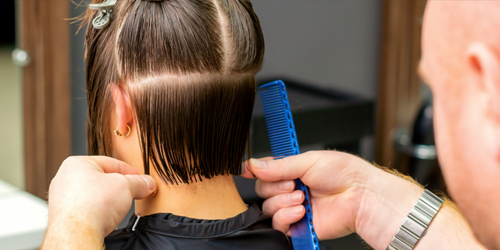 a hairdresser cutting the back of someones hair