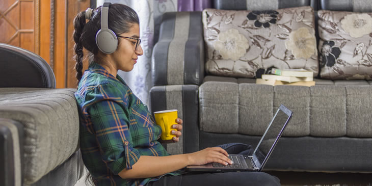 Student working with a laptop with headphones on