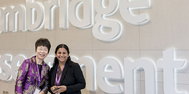 summit delegates in front of cambridge assessment logo