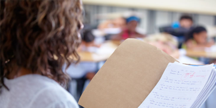 An over the shoulder view of a teacher reading out student marks