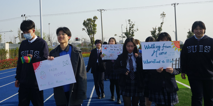 group of students in China out walking and holding a poster