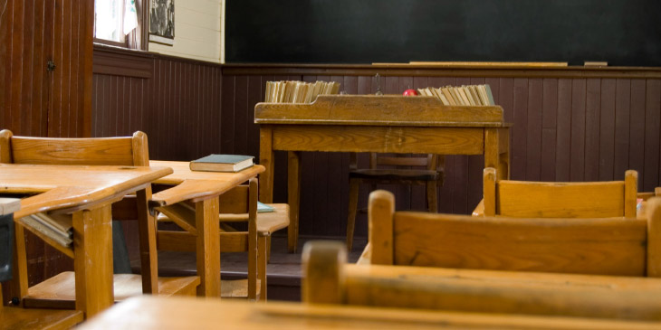 Wood paneled classroom with old wooden desks